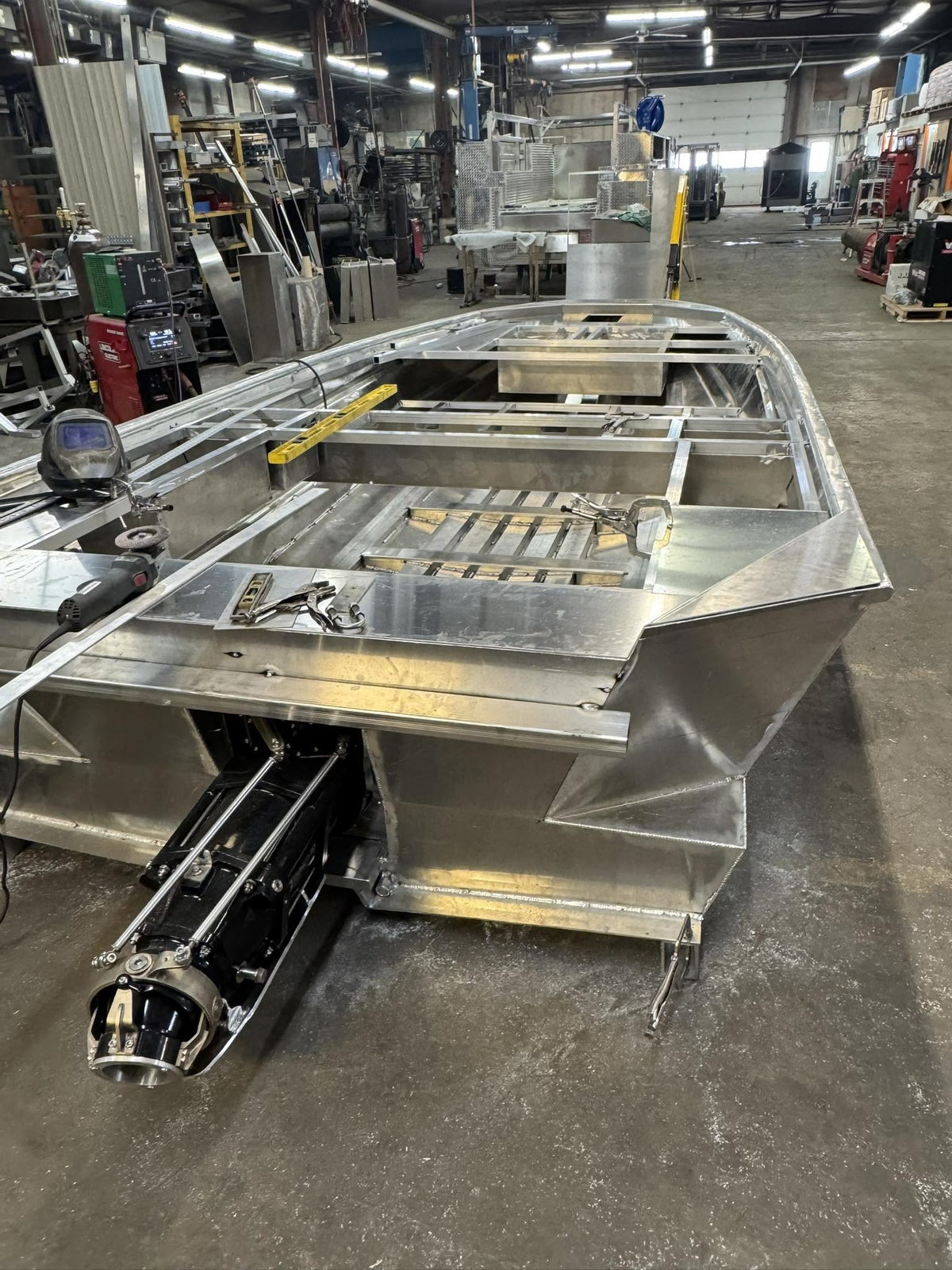 A Banshee hull under construction in the shop, with the inboard jet drive alongside
