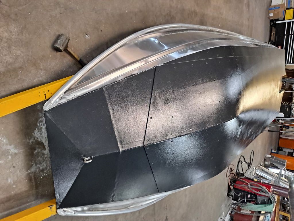 An armored Banshee hull upside down in the shop